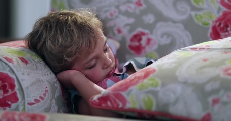 Wall Mural - Cute candid child sleeping on sofa at night. Tired toddler boy slouched on couch