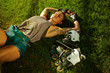 © splitov27 - Young cheerful sport woman roller skater resting lying on the lawn grass in the park and listens to music with headphones
