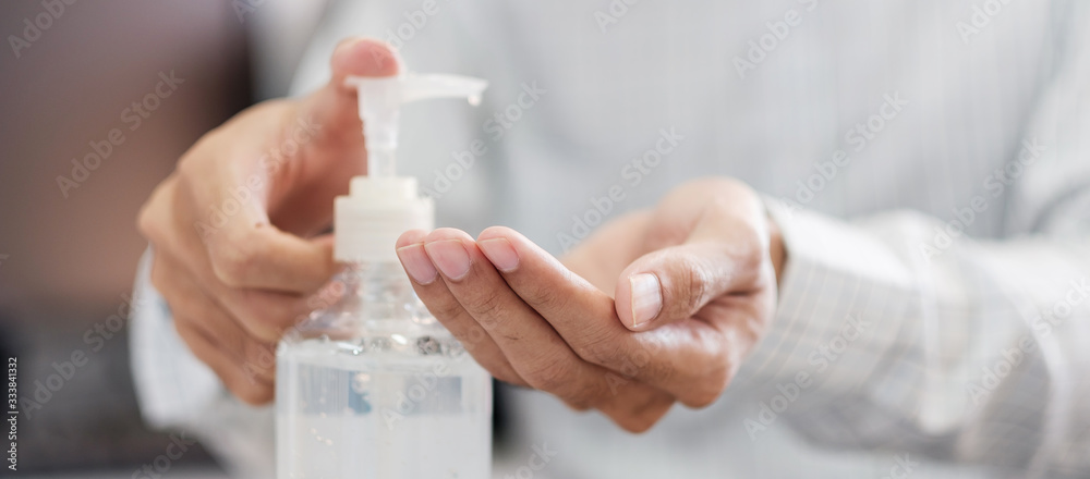 Man hands using wash hand alcohol gel or sanitizer bottle dispenser, against Novel coronavirus or Corona Virus Disease (Covid-19) . Antiseptic, Hygiene and Health concept - obrazy, fototapety, plakaty 