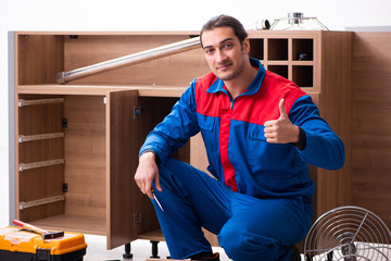 Young handsome male carpenter working indoors