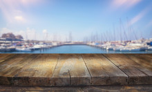 Background Of Wood Deck In Front Of Blurred Marina Beach And Sea With Boates, Yacht. Ready For Product Display