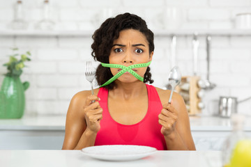 Wall Mural - Afro woman with green measuring tape around her mouth