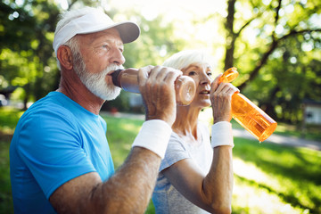 Wall Mural - Active mature couple running in the park for helathy life