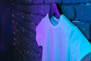 White color unisex t-shirt in neon light , copy space