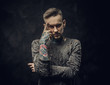© Fxquadro - Assertive male model posing in a dark studio wearing ripped longsleeve jumper, tattooed in a japanese irezumi style, looking tired