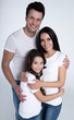 © My Ocean studio - Happy beautiful young family in white t-shirts while they hugging each other isolated on a light background.