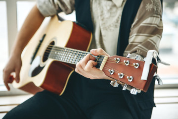 Wall Mural - The guitarist plays the guitar. Or a person learns to play the guitar.