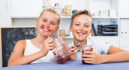 Girl and boy are eating jam