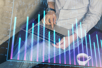 Forex graph with businessman working on computer in office on background. Concept of analysis. Double exposure.