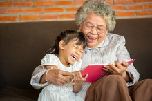 Closeup Photo Of Grandmother Teaches To Read A Book Her Granddaughter,Family Concept.
