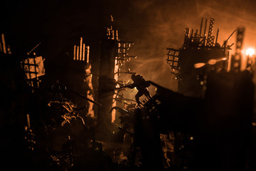 Army sniper with large caliber rifle standing in the fire and smoke. Backlit silhouette, toned image