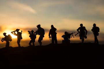 Wall Mural - War Concept. Military silhouettes fighting scene on war fog sky background, World War Soldiers Silhouette Below Cloudy Skyline At sunset.