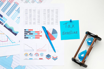 Wall Mural - Documents with hourglass and text TAX DEADLINE on white background