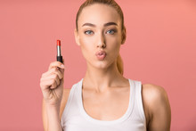 Blonde Woman Holding Lipstick Pouting Lips Standing In Studio