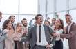 © ASDF - happy business man standing among his colleagues.