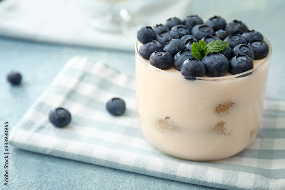 Tasty tiramisu with berries on color background