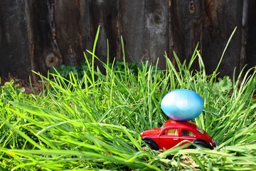 Poster - Red car with blue easter egg on grass