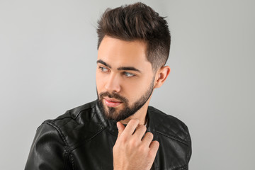 Handsome man with healthy hair on light background