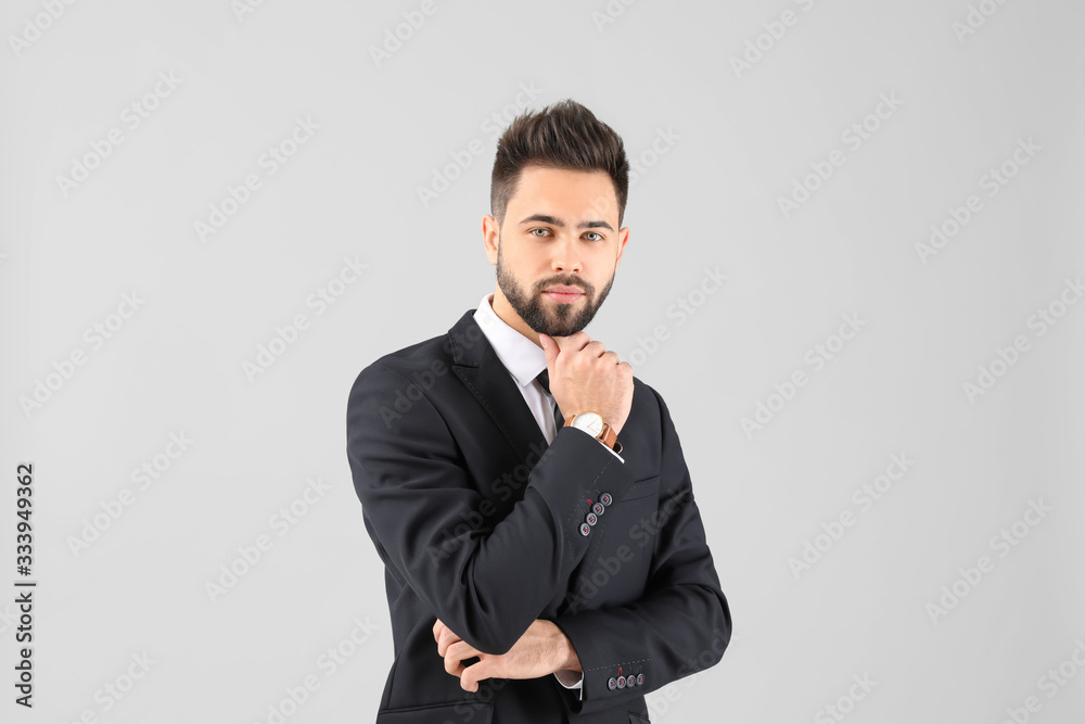 Handsome businessman with healthy hair on light background