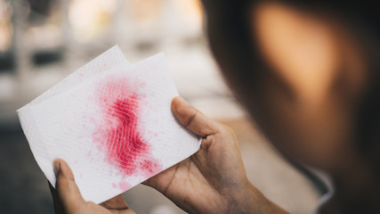 Woman have a coughing up blood  hands holding tissue paper with bloody