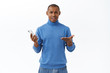 © Cookie Studio - Technology, online lifestyle concept. Portrait of displeased young african-american man shrugging in dismay, being disappointed, holding mobile phone, read strange frustrating news internet