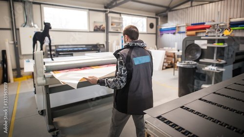 Fotografía Technician works in large printing press hall and printshop office