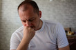 © Nenad - Sad mid adult man thinking at home. Mental health during the coronavirus outbreak. Feeling hopeless. Indoor close-up image of disturbed, sad, Caucasian, mid adult man.