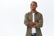 © Cookie Studio - Portrait of pleased and proud handsome african-american man, cross arms on chest confident, contemplating something pleasant, smiling delighted, look left satisfied, white background