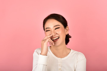 Wall Mural - Asian woman laughing and enjoy on pink background, Portrait of happy smiling middle age woman in casual clothes looking at the camera.