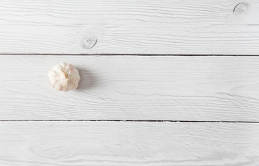 Head of garlic on white wood background