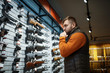 © Nomad_Soul - Man looking on handguns, showcase in gun shop