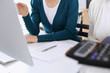 © Iryna - Accountant checking financial statement or counting by calculator income for tax form, hands closeup. Business woman sitting and working with colleague at the desk in office. Tax and Audit concept