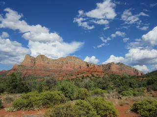 View of red rock mountains near Sedona, Arizona with clouds and blue sky in the background 