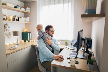 Young father working from home and babysitting.