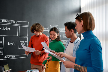 Wall Mural - young professionals. group of four web designers in casual wear developing new web site layout while