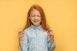 © Roman - portrait of caucasian girl believing in the best, she crossed fingers and stand with closed eyes, isolated over yellow background. believe, pray concept