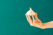 Hand holding a garlic. Green background. Concept: healthy living, eat local food, immune system. Creative banner. Copy space. Isolated.