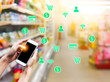 © Chan2545 - Blurred background of supermarket store with mobile online shopping to order groceries foods and goods delivery to home. Demand e-commerce of the service increase during coronavirus quarantine