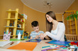 © Andrii - A young mother is doing homework with her son at home. Parents and training
