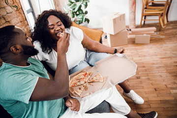 Afro American couple enjoying fast food at home stock photo