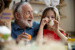 © Yakobchuk Olena - Happy elderly man preparing for Easter with granddaughter stock photo