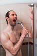 © Teodor Lazarev - Handsome young single male washing his body and face in bathroom.