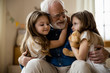 © Yakobchuk Olena - Mirthful children hugging their grandpa stock photo
