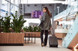 © Yakobchuk Olena - Beautiful lady with trolley bag walking in departure lounge