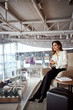 © Yakobchuk Olena - Beautiful young woman sitting in chair in airport waiting room