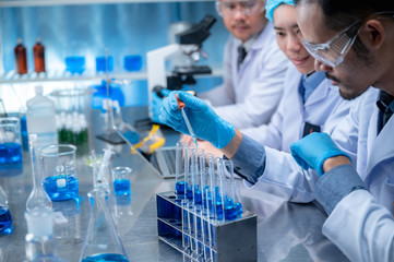 Wall Mural - science and medicine, scientist analyzing and dropping a sample into a glassware, experiments contai