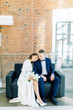 © pavelvozmischev - The bride and groom's romantic photo shoot. The newlyweds are happy together. Stylish modern couple in a light interior.