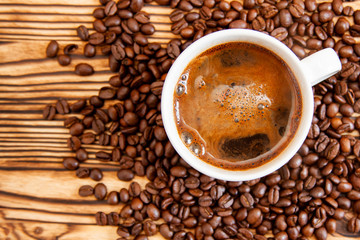 White cup of coffee stands on coffee beans