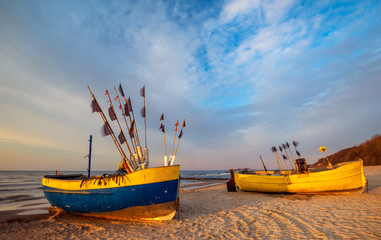 Wall Mural - colorful fishing boats on a sandy sea beach during a beautiful sunset