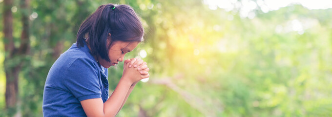 Wall Mural - Pray concept.Asian child praying,hope for peace and free from disease,Hand in hand together by kid ,believes and faith in christian religion at church-panoramic banner for web header